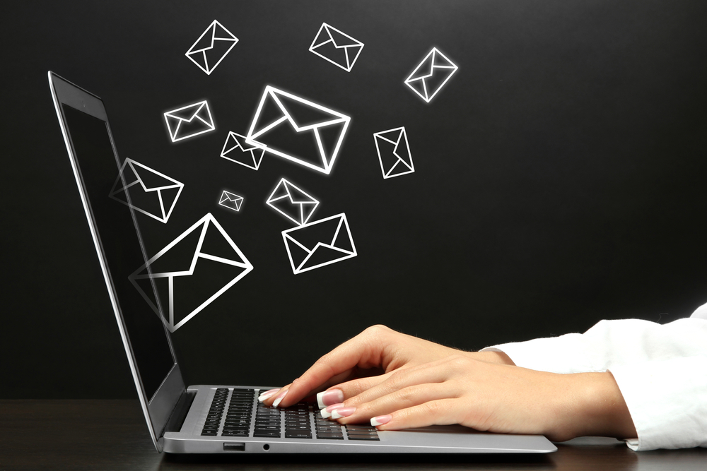 Client success shown through many emails being sent from a laptop
