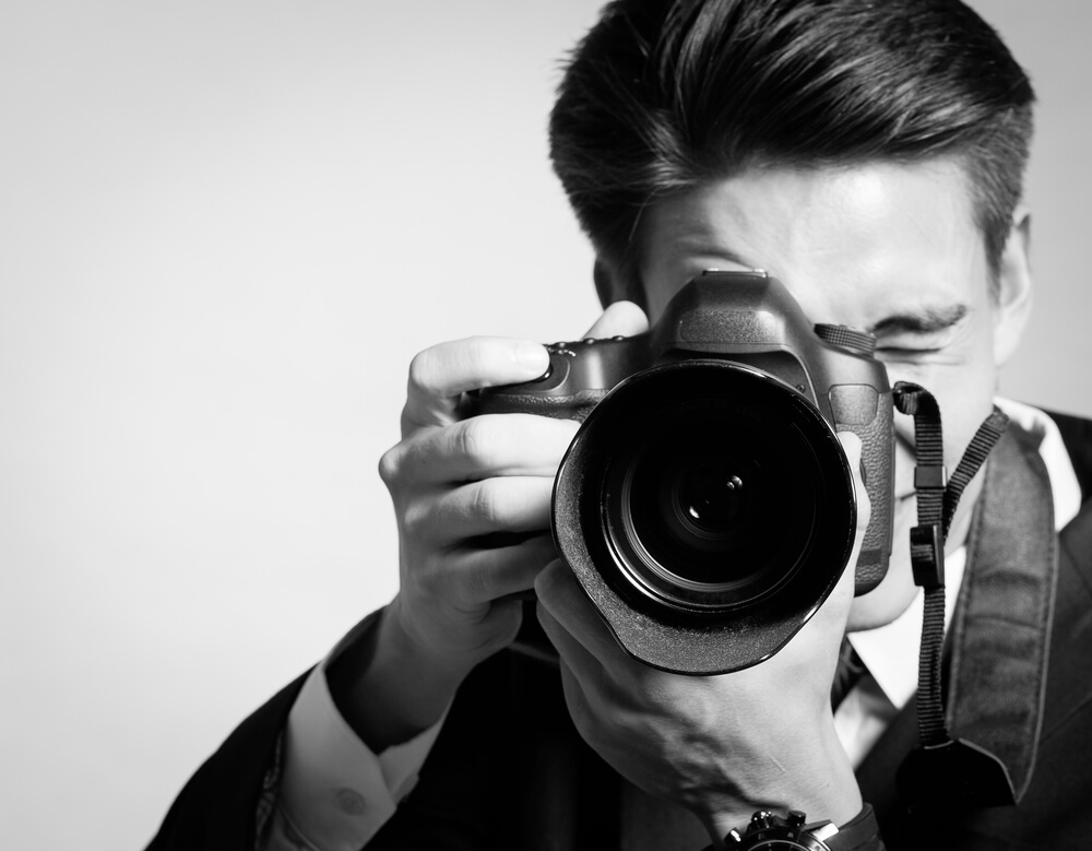 10 Reasons Why Your Business Needs Professional Photography- Young man using a professional camera