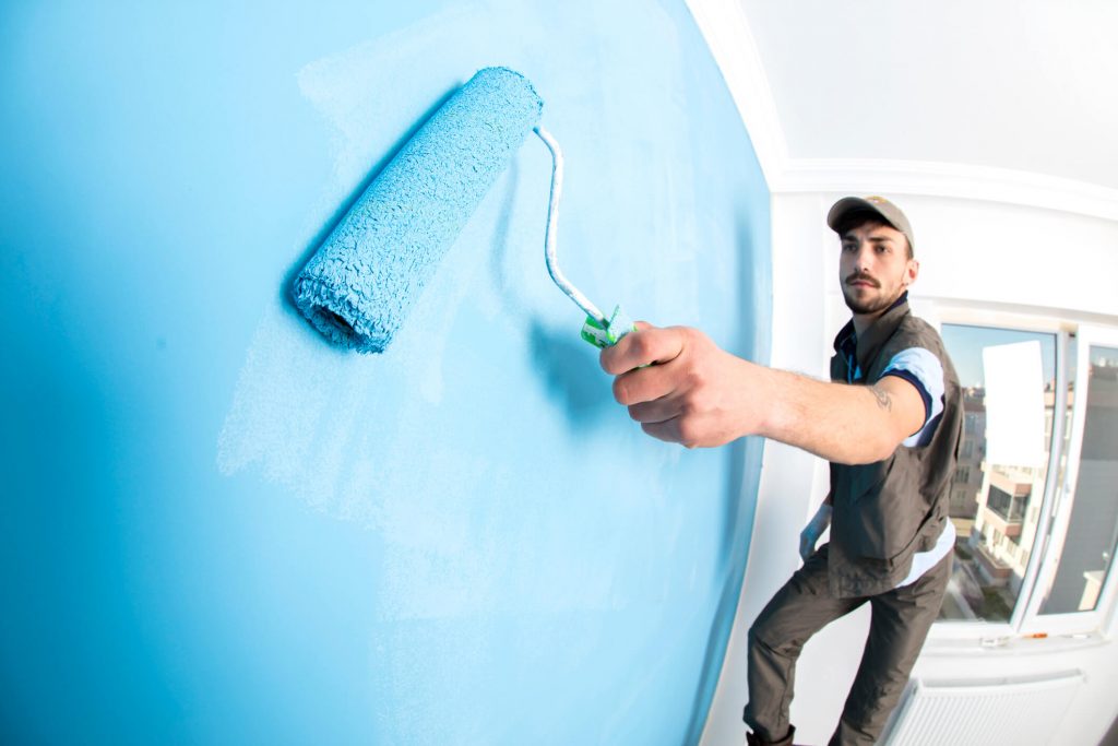 Painter painting a wall blue
