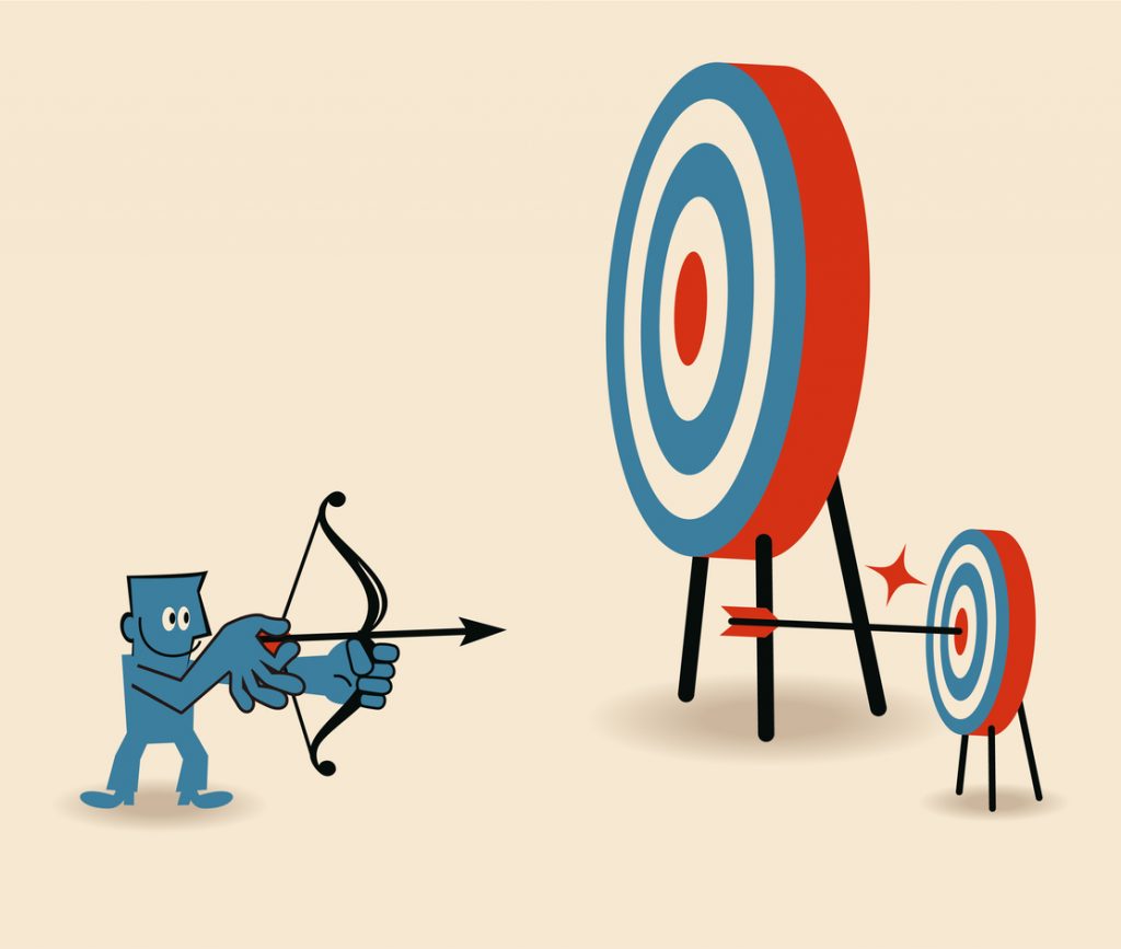 Businessman aiming at smaller target and shooting on Bull's-Eye of dartboard